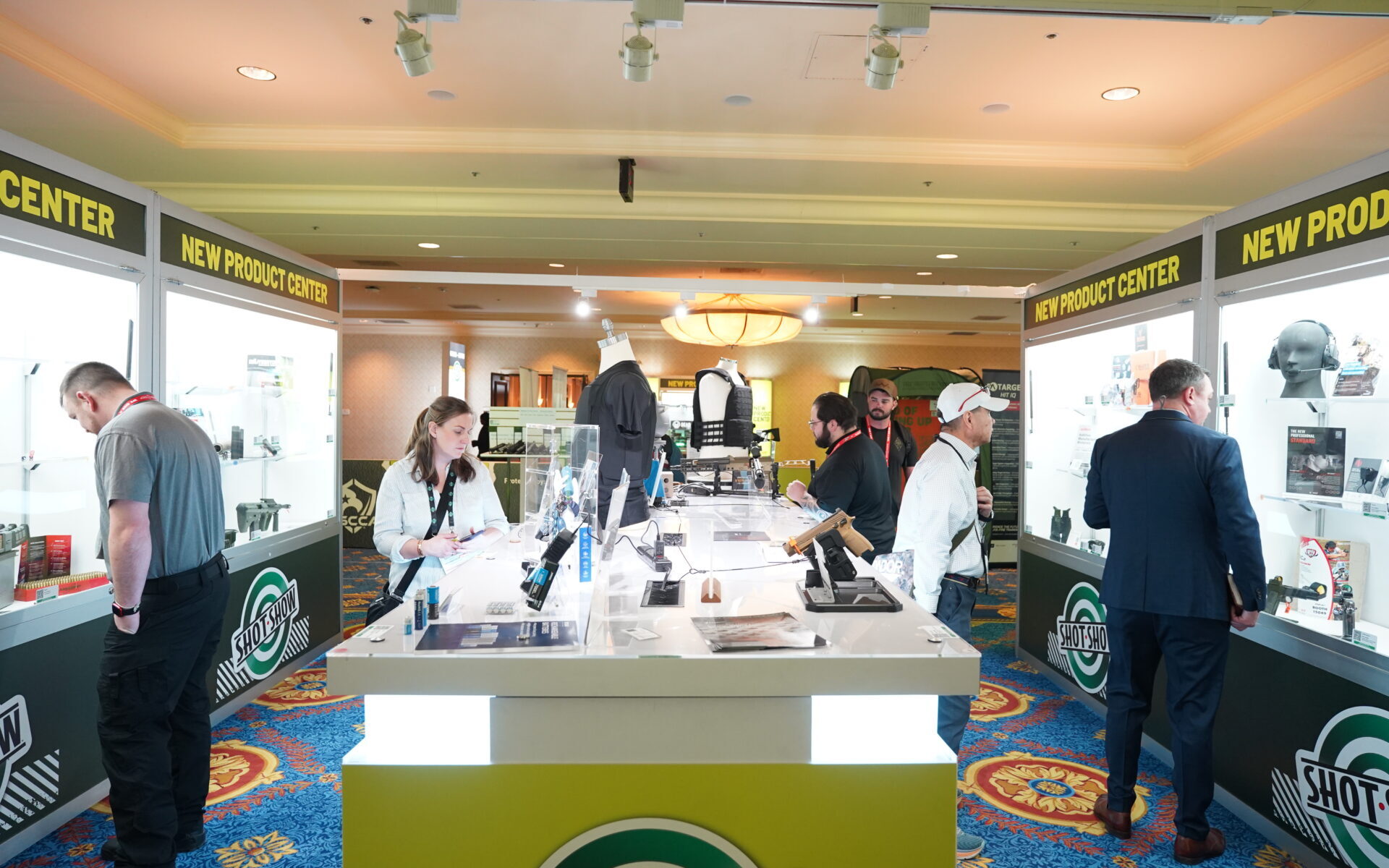 SHOT Show New Product Center exhibit floor showing firearms and outdoor industry products and retailers evaluating new product offerings